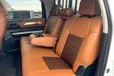 Exotic Seat Covers installed on a rear bench seat, featuring tan ostrich texture with dark brown inserts and center armrest access.