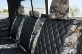 Luxury Line Kryptek camo seat covers shown on rear bench with three headrests, black quilted centers and camo bolsters.