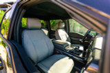 Front seats of a car fitted with durable Cordura fabric seat covers in gray, viewed from the open door.