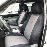Two-tone charcoal and light grey custom-fit NeoSupreme seat covers installed on the driver and passenger seats of a modern vehicle.