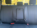 Rear bench seat back protected by solid black NeoSupreme seat covers, featuring a dedicated opening for the center armrest and seatbelt.