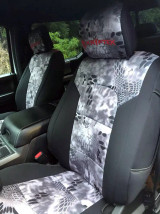 Front bucket seats with custom-fit Kryptek® seat covers in a grey and white "Raid" camo pattern, accented by black side bolsters for a sporty, rugged look.