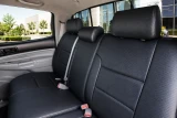 Luxury Line Carbon Fiber seat covers on front row, armrest, and rear bench, black weave with stitched horizontal panels.