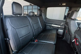 Interior view of Luxury Line Carbon Fiber Seat Covers installed on rear truck seats, featuring a durable carbon fiber weave pattern.