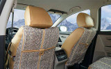 Rear view of Luxury Line Saddle Blanket Seat Covers in a car, showing woven fabric and tan custom-fit headrests.