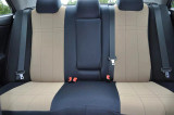 Rear bench seat protected by tan and black neoprene seat covers, showcasing a precise fit that allows full access to seat belts and center armrests.