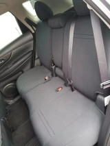 Rear bench seat of an SUV completely covered with dark grey neoprene, demonstrating a precise, tailored fit that maintains full functionality of seat belts and folding mechanisms.