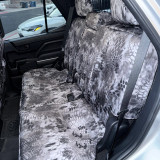 Rear bench seat fully protected with Kryptek® Waterproof Camo seat covers in the "Raid" pattern, demonstrating a precise fit and durable, weather-resistant material.