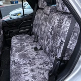 Rear bench seat fully protected with Kryptek® Waterproof Camo seat covers in the "Raid" pattern, demonstrating a precise fit and durable, weather-resistant material.