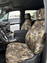 Kryptek Waterproof seat covers on GMC front buckets, Highlander tan-green camo with black quilted console armrest.