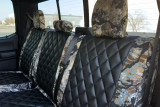 Luxury Line Kryptek camo seat covers shown on rear bench with three headrests, black quilted centers and camo bolsters.