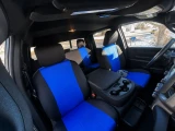 A full set of blue and black neoprene seat covers installed in a truck, providing comprehensive protection for both front and rear rows with a vibrant, athletic aesthetic.