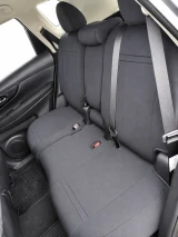 Rear bench seat of an SUV completely covered with dark grey neoprene, demonstrating a precise, tailored fit that maintains full functionality of seat belts and folding mechanisms.