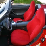 High-back bucket seats in a red convertible outfitted with vibrant red custom-fit neoprene seat covers, creating a bold, sporty, and unified look for the vehicle's interior.
