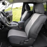 Front cabin of a truck with grey and black neoprene seat covers, providing a durable, snug fit that protects the original upholstery from daily wear and tear.