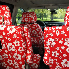 Hawaiian seat covers on middle-row seat backs, full red with white hibiscus print covering headrests and backrests.