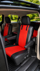 Imitation Leather seat covers on minivan second-row captain chairs, red centers with black bolsters and vertical stitching.