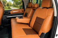 Exotic Seat Covers installed on a rear bench seat, featuring tan ostrich texture with dark brown inserts and center armrest access.