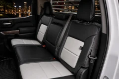 Exotic Seat Covers on rear bench seat, black and light gray custom-fit protection with center console access.
