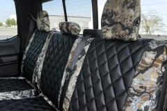 Luxury Line Kryptek camo seat covers shown on rear bench with three headrests, black quilted centers and camo bolsters.