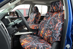 Front seat view of Luxury Line Moon Shine Seat Covers (Wildfire), featuring a bold orange and red branch camo pattern.