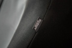 Detailed close-up of a Side Airbag safety tag on the seam of a black, heavy-duty custom seat cover.
