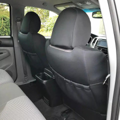 Rear view of front seats equipped with solid black NeoSupreme seat covers, featuring integrated map pockets for extra storage.