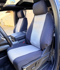 NeoSupreme seat covers on Ford truck front buckets, charcoal bolsters with light gray stitched centers and headrest wraps.