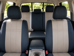 NeoSupreme seat covers front and rear, black bolsters with tan grid-stitched centers on buckets and rear bench.