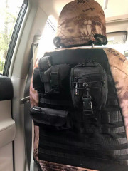 Rear view of a front seat equipped with a Kryptek® Camo cover in a desert tan pattern, featuring an integrated tactical MOLLE system with multiple utility pouches for organized storage.