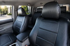 Luxury Line Carbon Fiber seat covers on truck rear bench with three headrests, black twill carbon weave and seatbelt cutouts.