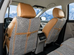 Rear view of Luxury Line Saddle Blanket Seat Covers in a car, showing woven fabric and tan custom-fit headrests.