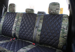 Luxury Line MultiCam Seat Covers installed on a truck's rear bench seat, featuring black diamond-stitched inserts and MultiCam camo bolsters.