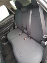 Rear bench seat of an SUV completely covered with dark grey neoprene, demonstrating a precise, tailored fit that maintains full functionality of seat belts and folding mechanisms.