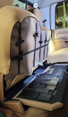 Neoprene seat cover on folded front seat back, tan sides with taupe center panel secured by black nylon straps and buckles.