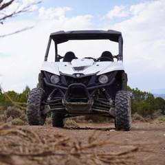 Front view of a white Yamaha side-by-side vehicle outdoors, highlighting its rugged design and off-road capability.