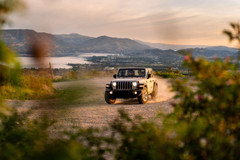 White Jeep driving on a scenic mountain trail, protected by durable Kryptek Waterproof Camo Seat Covers.