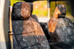 Close-up of Kryptek Typhon camo seat covers on front seats, showing the high-definition tactical pattern and headrest.