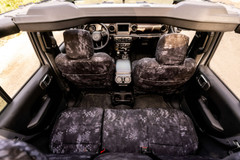 Interior view from above showing custom Kryptek Typhon camo seat covers installed on all vehicle seats.