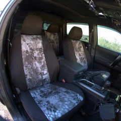 Kryptek waterproof camo seat covers on truck front and rear seats, black bolsters and grey hex Typhon-style center inserts.