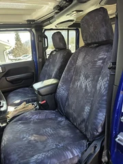 Kryptek Waterproof Camo seat covers on Jeep Wrangler front buckets, dark Typhon camo with securing straps at headrests.