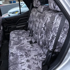 Rear bench seat fully protected with Kryptek® Waterproof Camo seat covers in the "Raid" pattern, demonstrating a precise fit and durable, weather-resistant material.