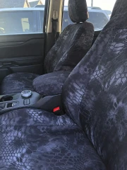 Kryptek Waterproof seat covers on front buckets with console, grey-black Typhon camo covering headrests and armrest.