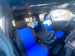 A full set of blue and black neoprene seat covers installed in a truck, providing comprehensive protection for both front and rear rows with a vibrant, athletic aesthetic.
