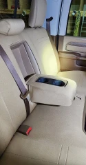 Neoprene seat covers on truck rear bench in solid tan, quilted stitching with fold-down armrest and cupholder cutouts.