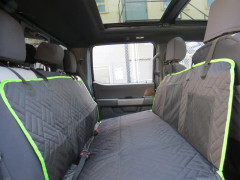 Universal Pet Seat Cover hammock-style, chevron-quilted black with neon green trim and mesh organizer pockets.