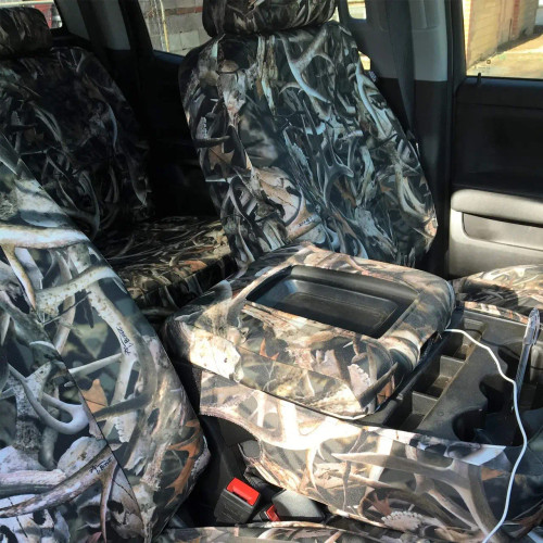 Bonz Waterproof Camo Seat Covers installed in a truck interior with full camo coverage, including console and cupholder access.
