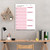 Whiteboard, a weekly planner with pink accents and space for notes, habits, and quotes, hanging on a neutral wall in a modern workspace.