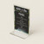 Flyer holder, clear acrylic stand with colorful tropical frame displaying a wedding menu.