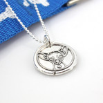 Chihuahua Wax Seal Inspired Necklace shown next to a blue leash with white dog bones
